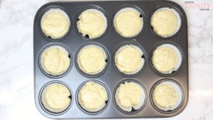 placing cupcake cases in a baking tray and pouring the batter
